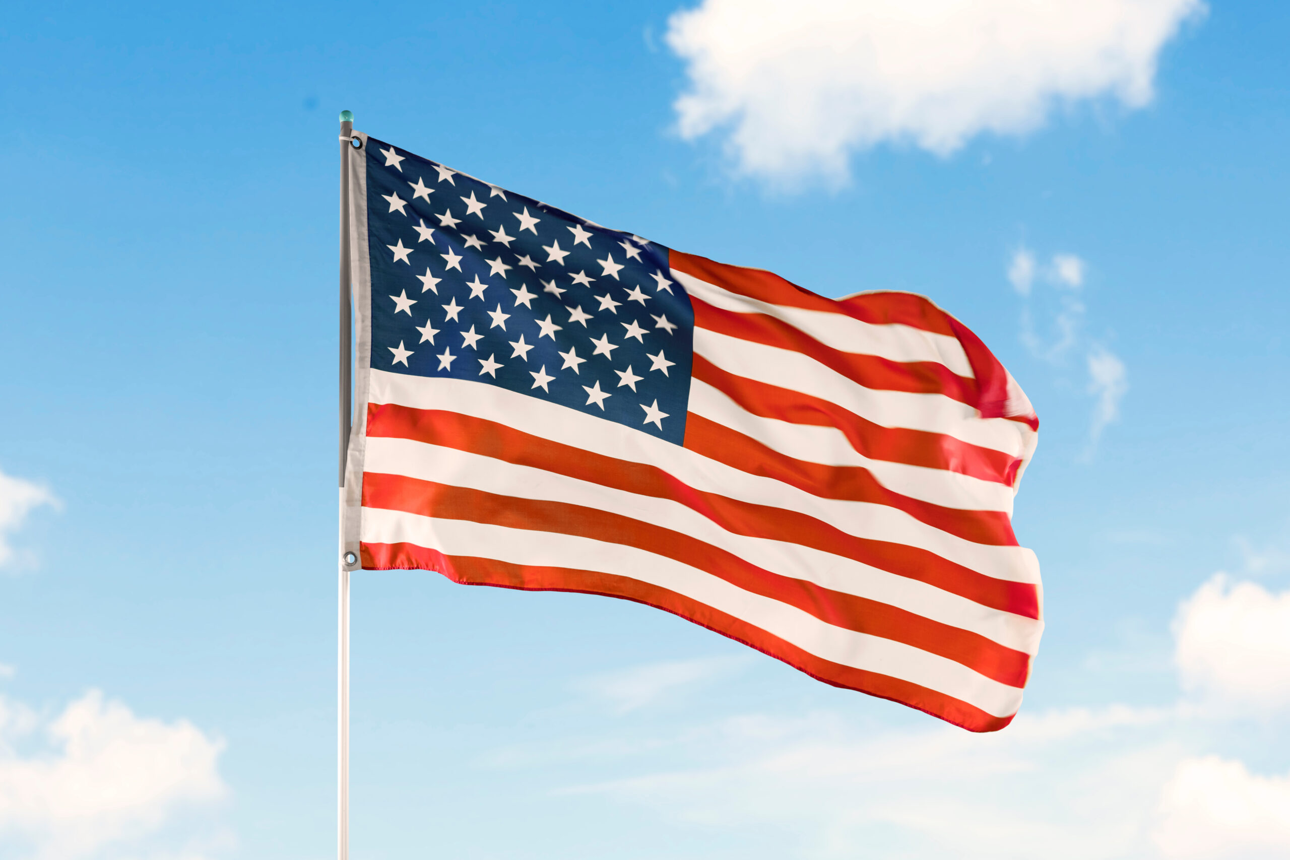American flag waving under blue sky